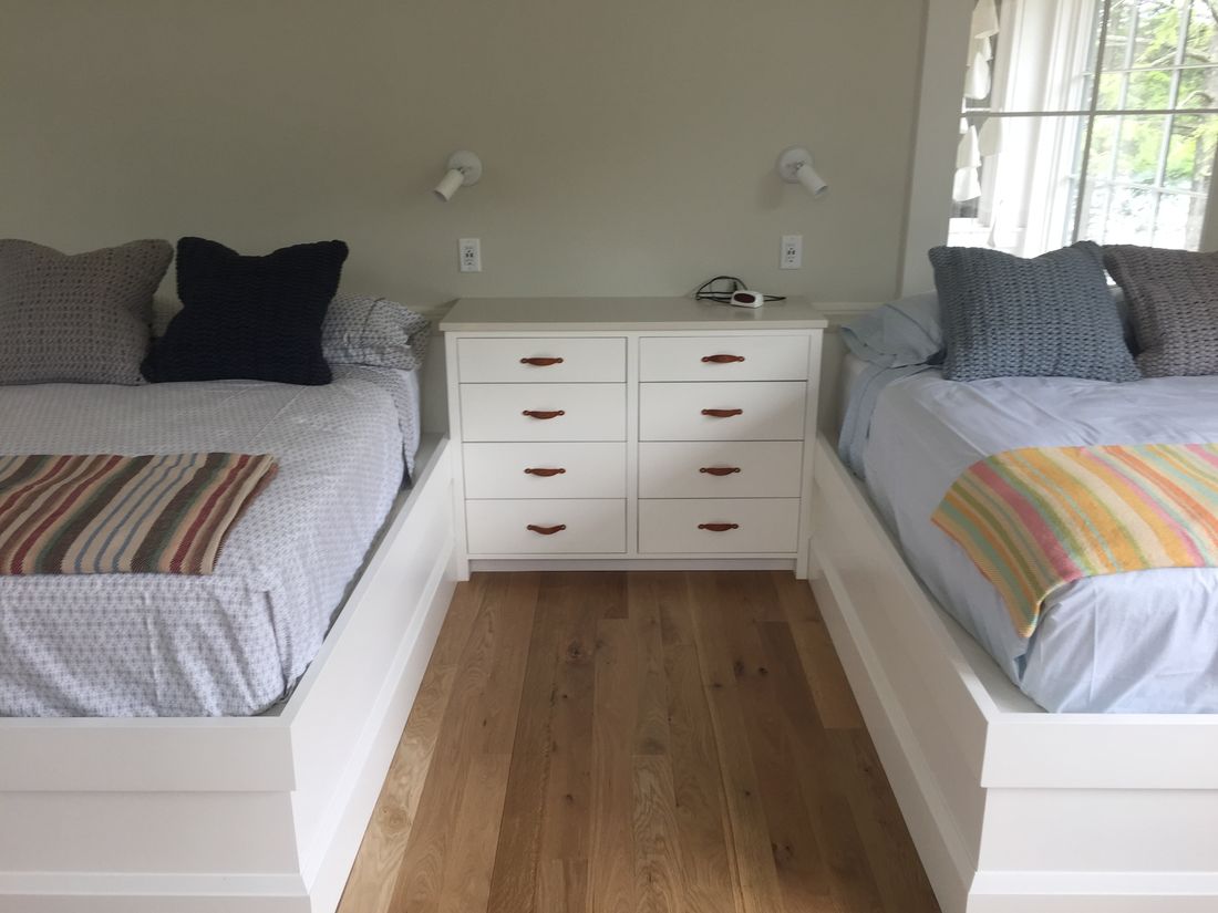 Built-in twin beds with drawer bases and a shared dresser between them