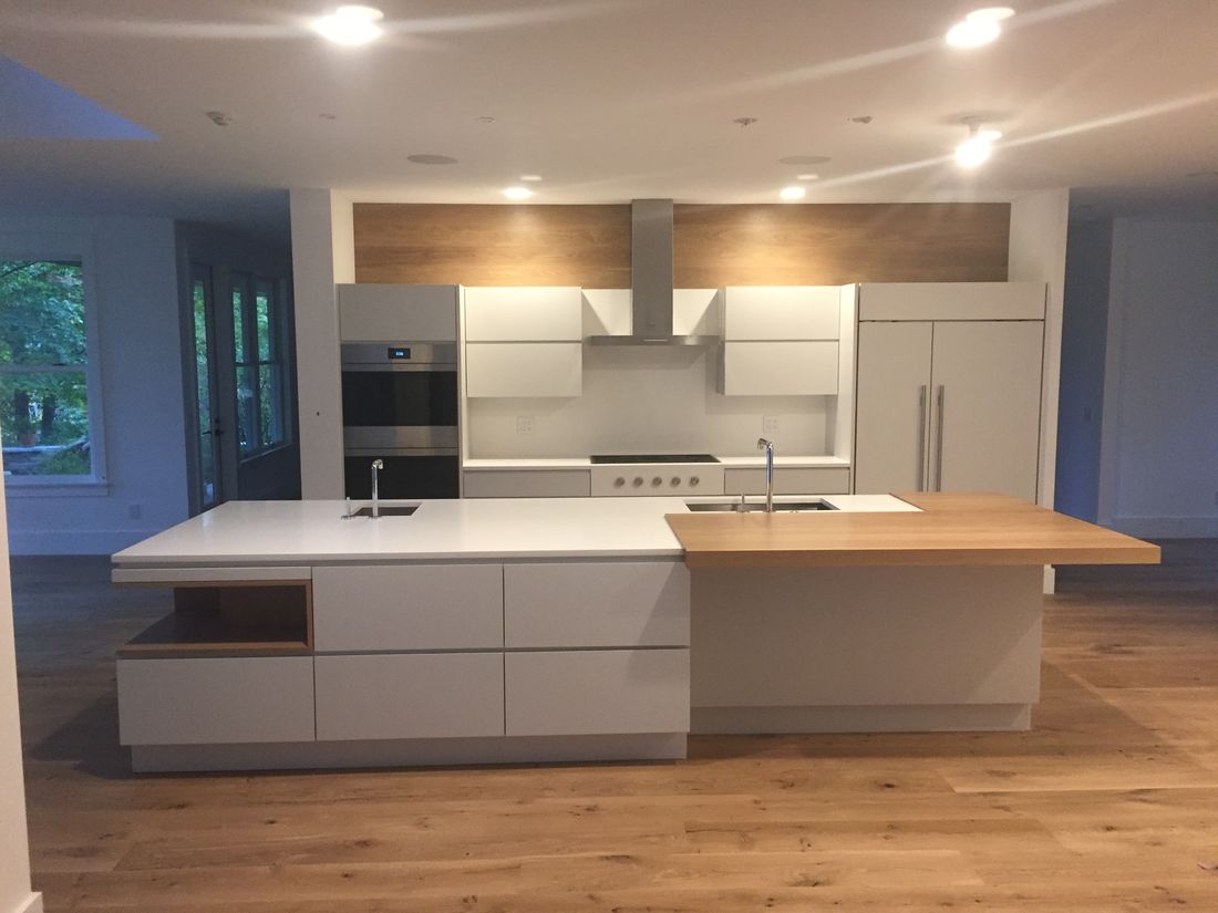 Modern flat-panel kitchen with a white island and an oak extension counter